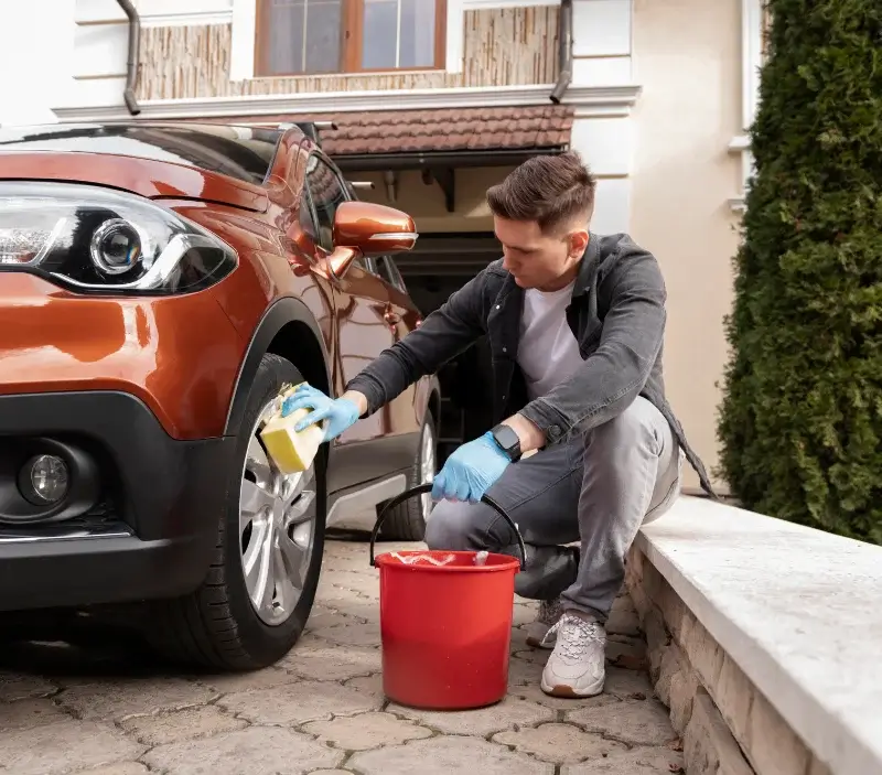 Lavage auto à domicile Le Brouilh-Monbert : professionnel intervenant sur un véhicule